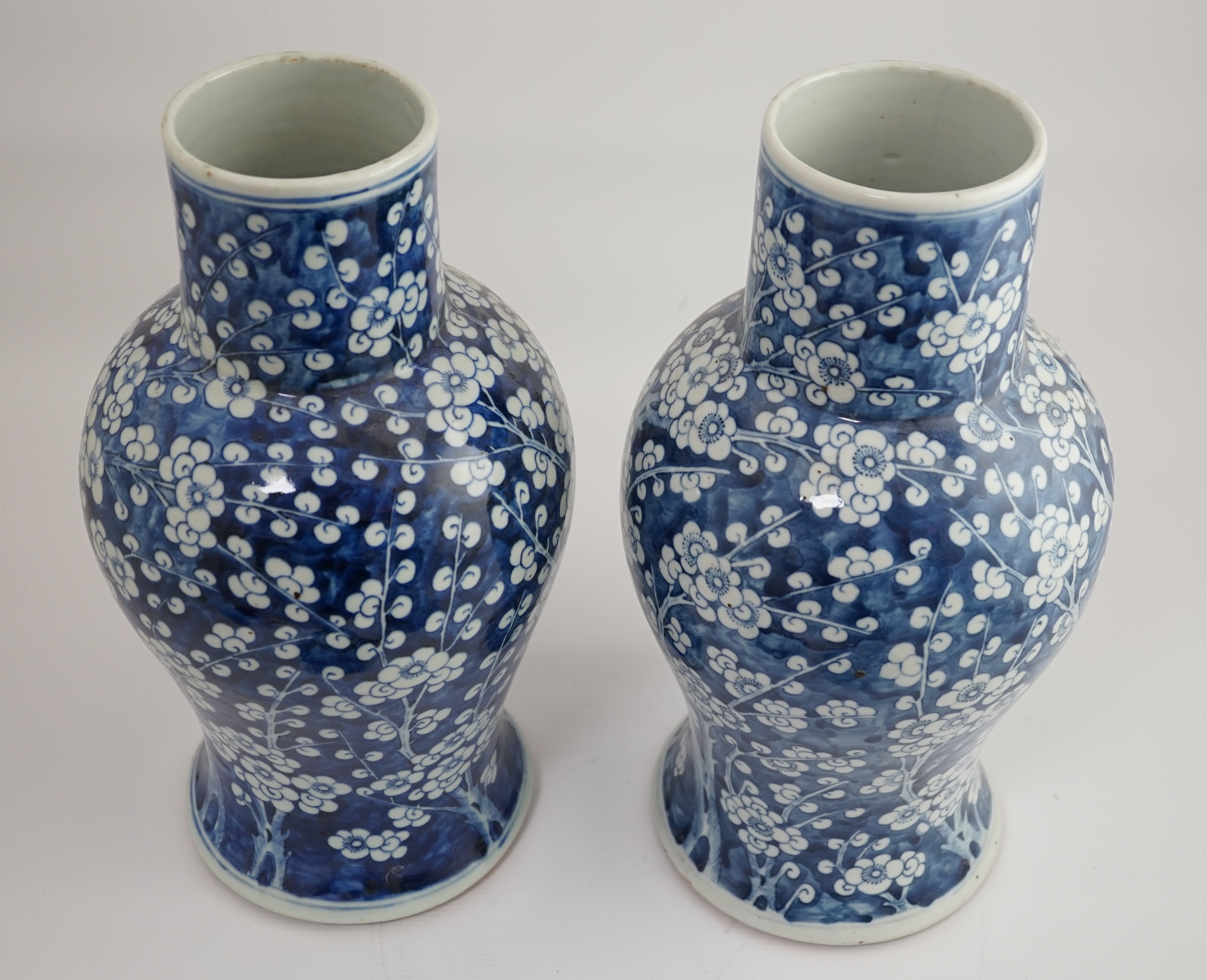 A pair of large Chinese blue and white ‘prunus’ baluster vases and covers, 19th century